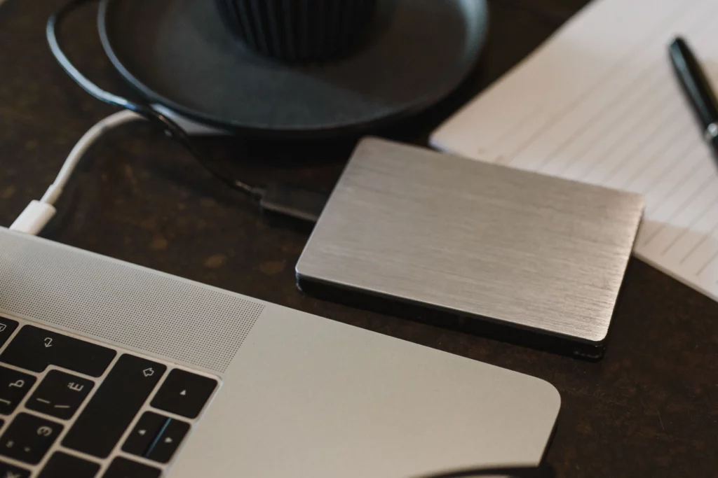 Un disque externe posé à côté d’un ordinateur de bureau